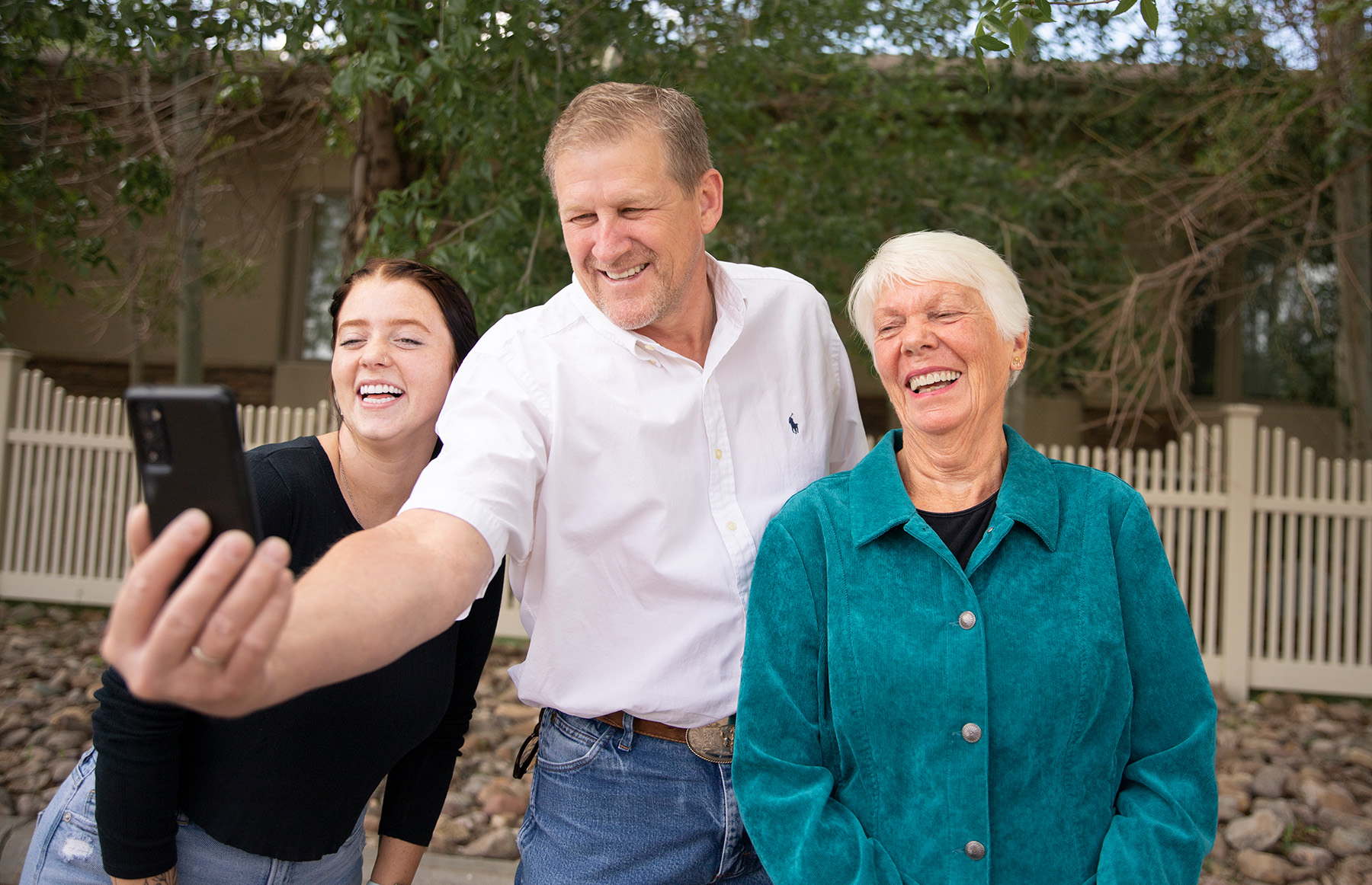 Three Wyo Dental Implants patients laughing as they take a selfie outside the Casper office
